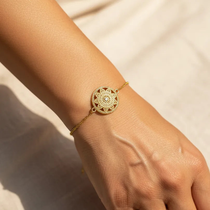 Woman wearing a gold mandala charm bracelet