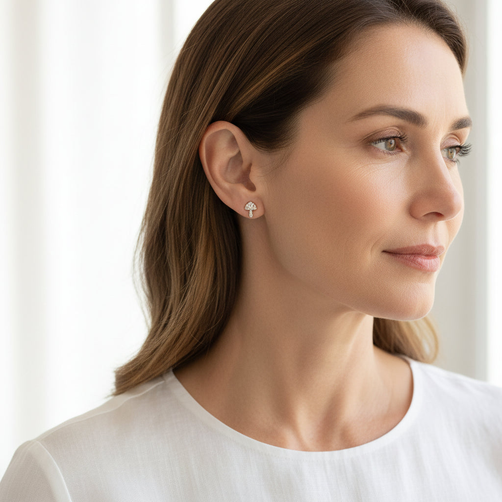 Woman wearing a tiny crystal mushroom stud earring in her earlobe
