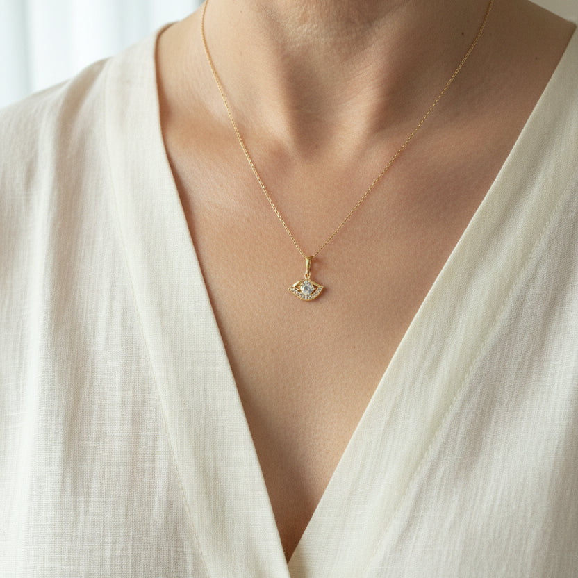 Gold plated crystal evil eye necklace worn at the neckline