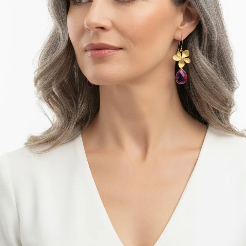 Woman wearing short orchid drop earrings with stone detail
