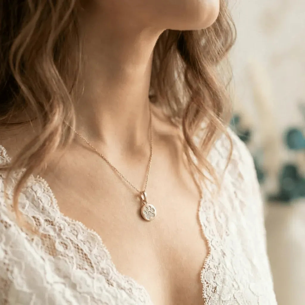 Woman wearing a gold crystal paw print necklace — crystal necklace for pet love