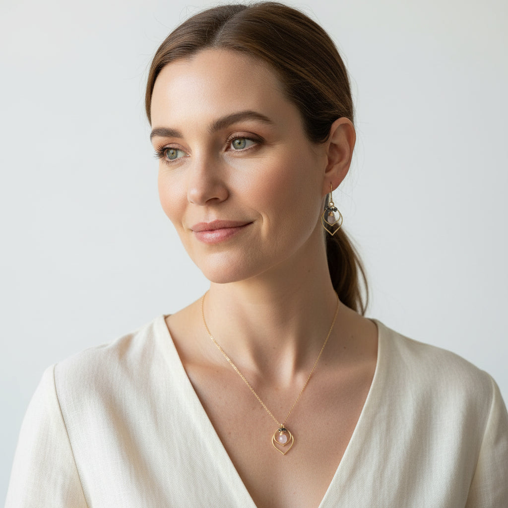 Woman wearing a pink chalcedony double teardrop necklace and matching earrings