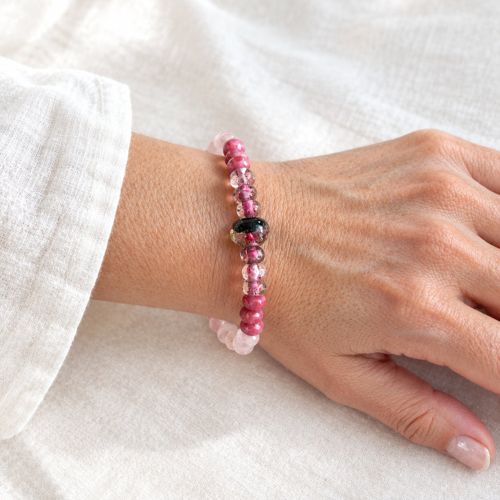 Woman wearing the rose quartz stretch bracelet with pink glass beads on her wrist