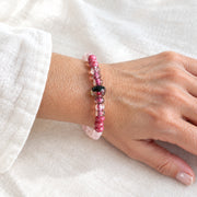 Woman wearing the rose quartz stretch bracelet with pink glass beads on her wrist