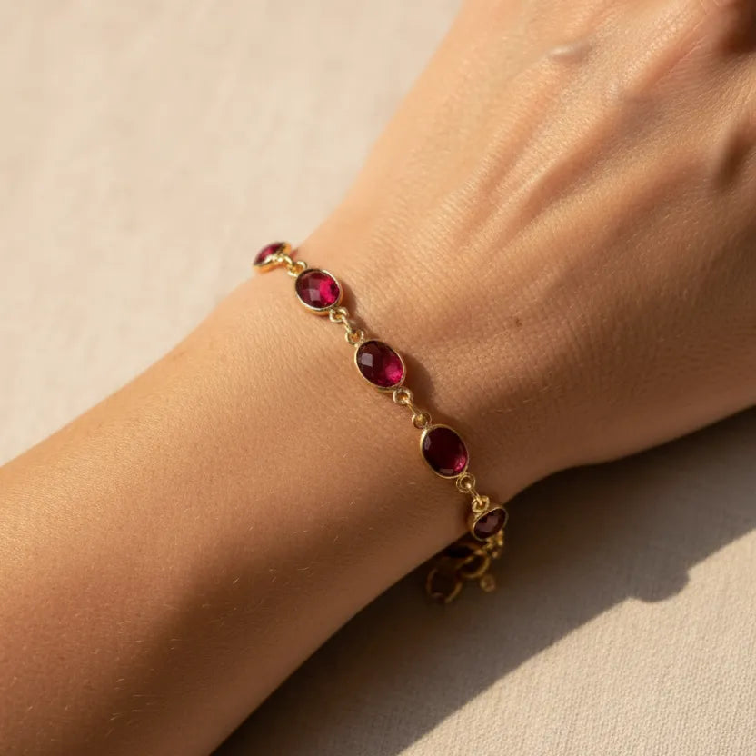 Close-up of a woman wearing pink tourmaline stones on her wrist, October birthstone jewelry