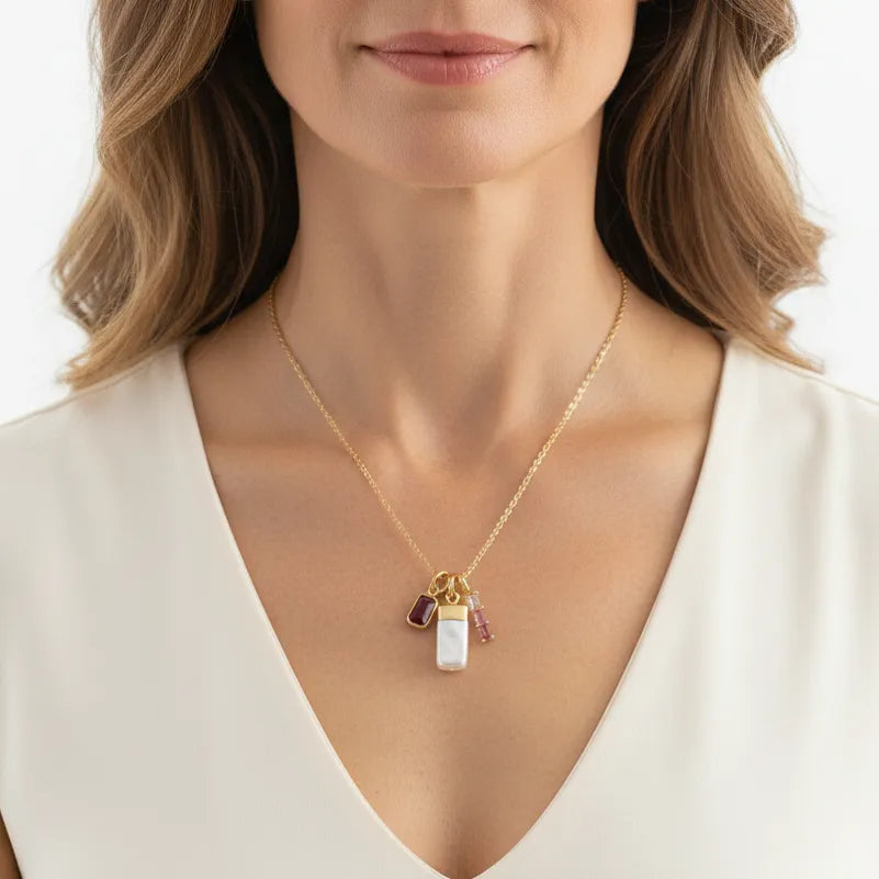 Woman wearing a pink tourmaline and pearl charm necklace, October birthstone jewelry