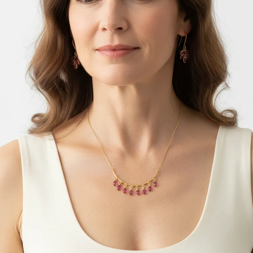 Woman wearing a pink tourmaline necklace, October birthstone jewelry