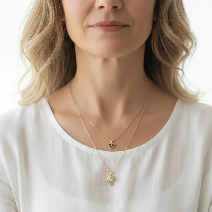 Woman wearing a planetary love necklace with an emerald green stone