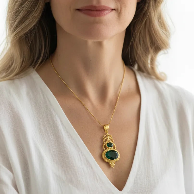 Woman wearing a green gemstone plume pendant necklace