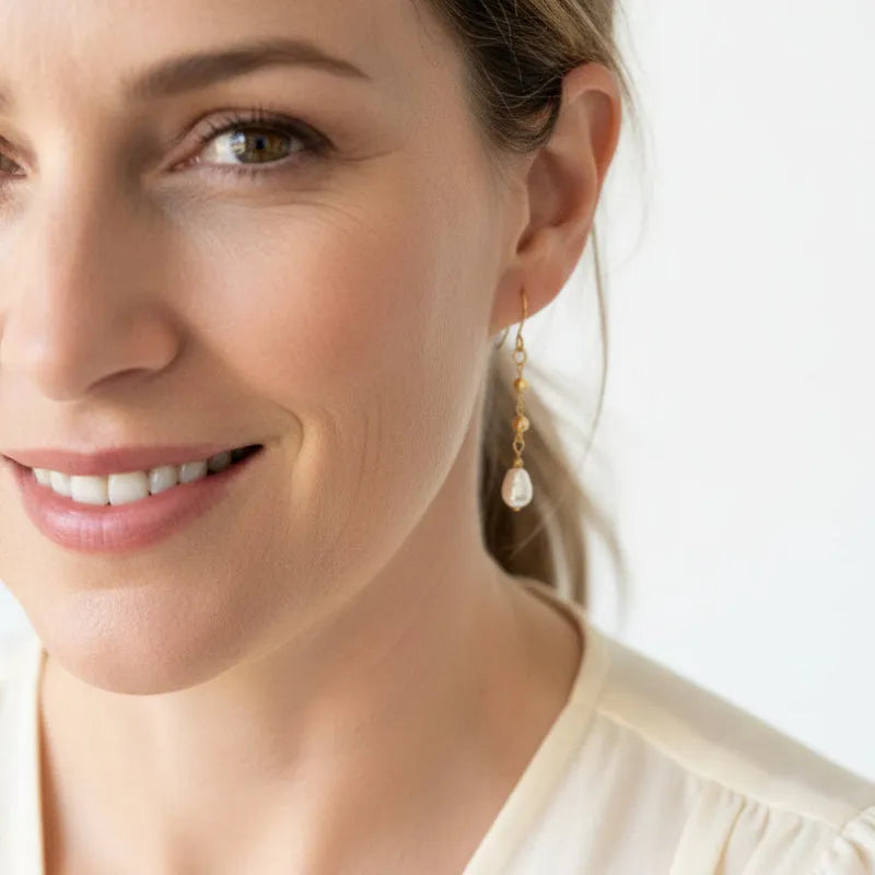Woman wearing gold pyrite chain drop earrings with freshwater potato pearls