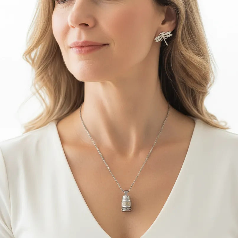 Woman wearing a prayer wheel necklace with dragonfly stud earrings, spirit animal jewelry