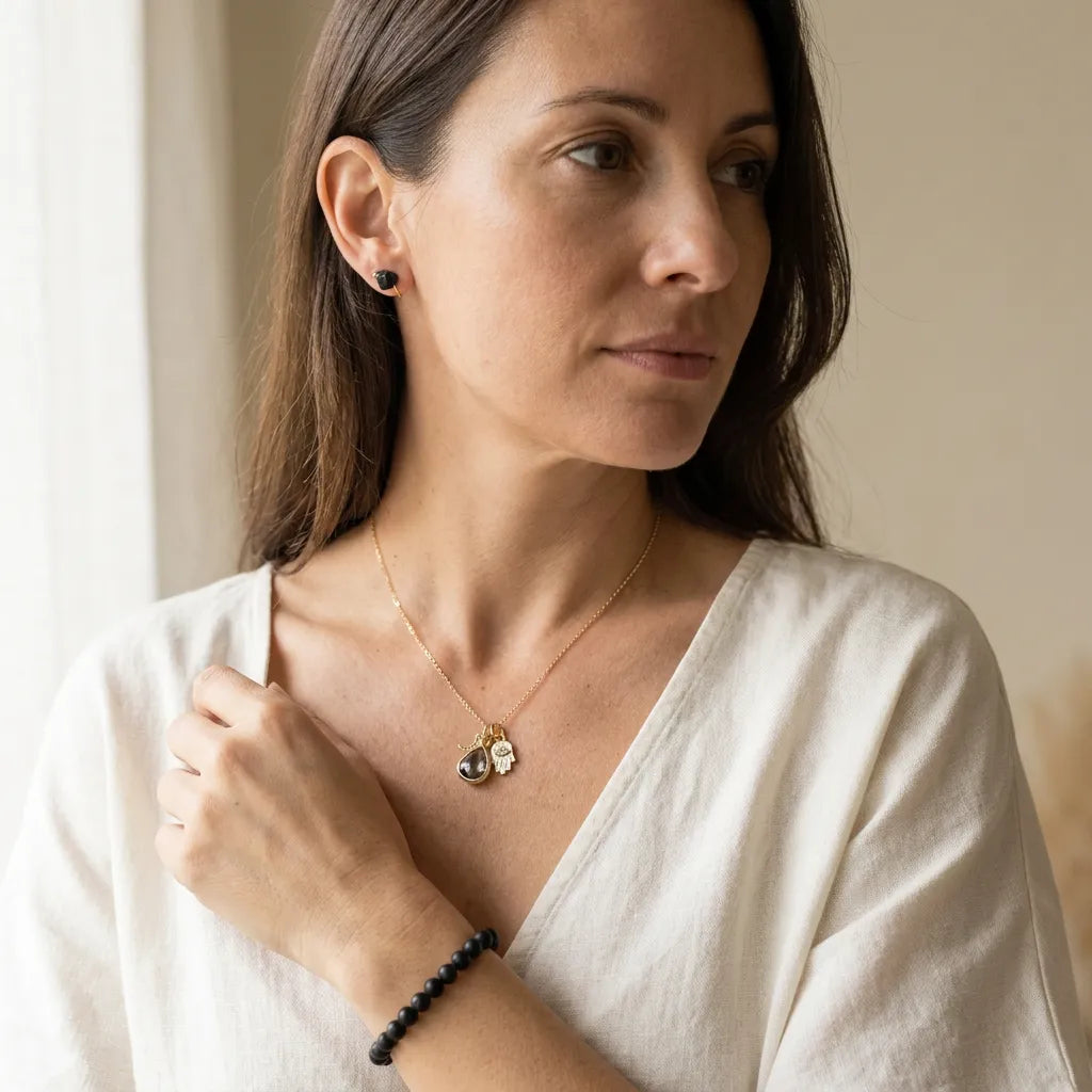Woman wearing hamsa necklace and black tourmaline protection set, protection symbol jewelry