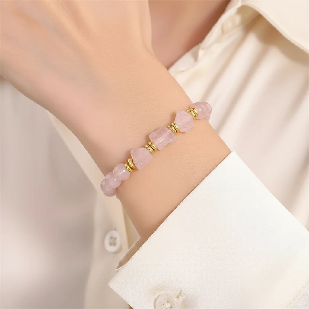 Woman wearing a rose quartz raw nugget stretch bracelet with 8 mm rough stone beads