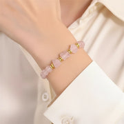 Woman wearing a rose quartz raw nugget stretch bracelet with 8 mm rough stone beads
