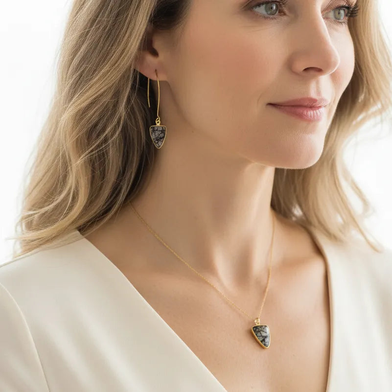 Woman wearing a black rutilated quartz shield necklace with matching earrings