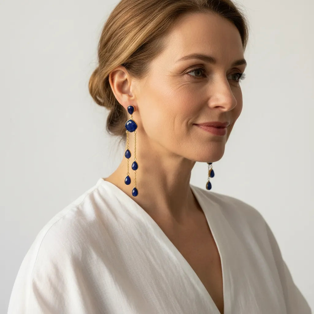 Woman wearing genuine sapphire statement drop earrings in gold, September birthstone jewelry