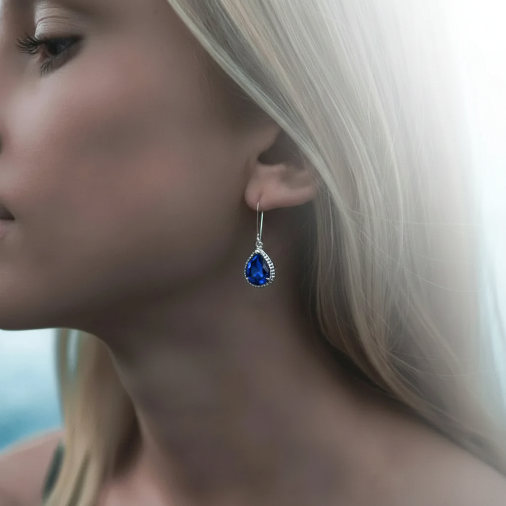 Woman wearing sapphire blue exquisite teardrop earrings in silver, September birthstone jewelry