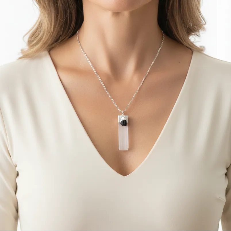 Woman wearing a selenite and black tourmaline pendant on silver