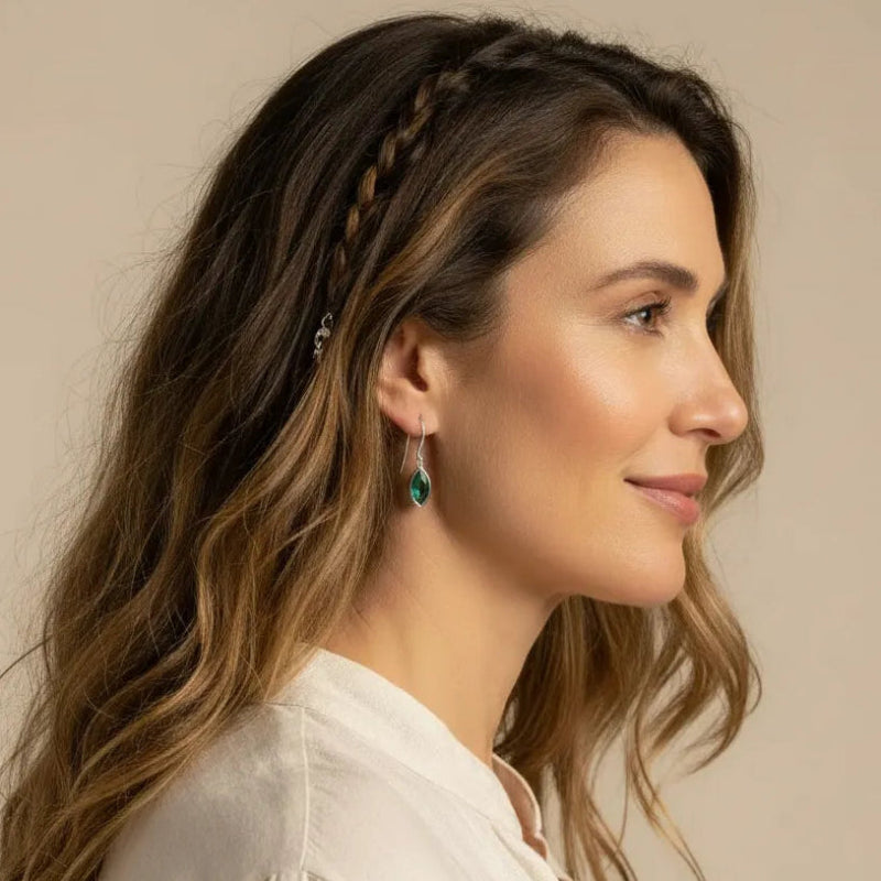 Woman wearing emerald green marquis drop earrings in silver