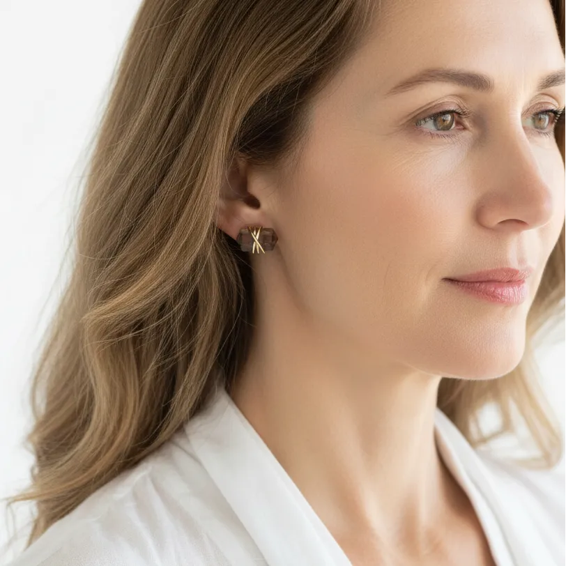 Woman wearing smoky quartz stud earrings in gold, grounding gemstone jewelry
