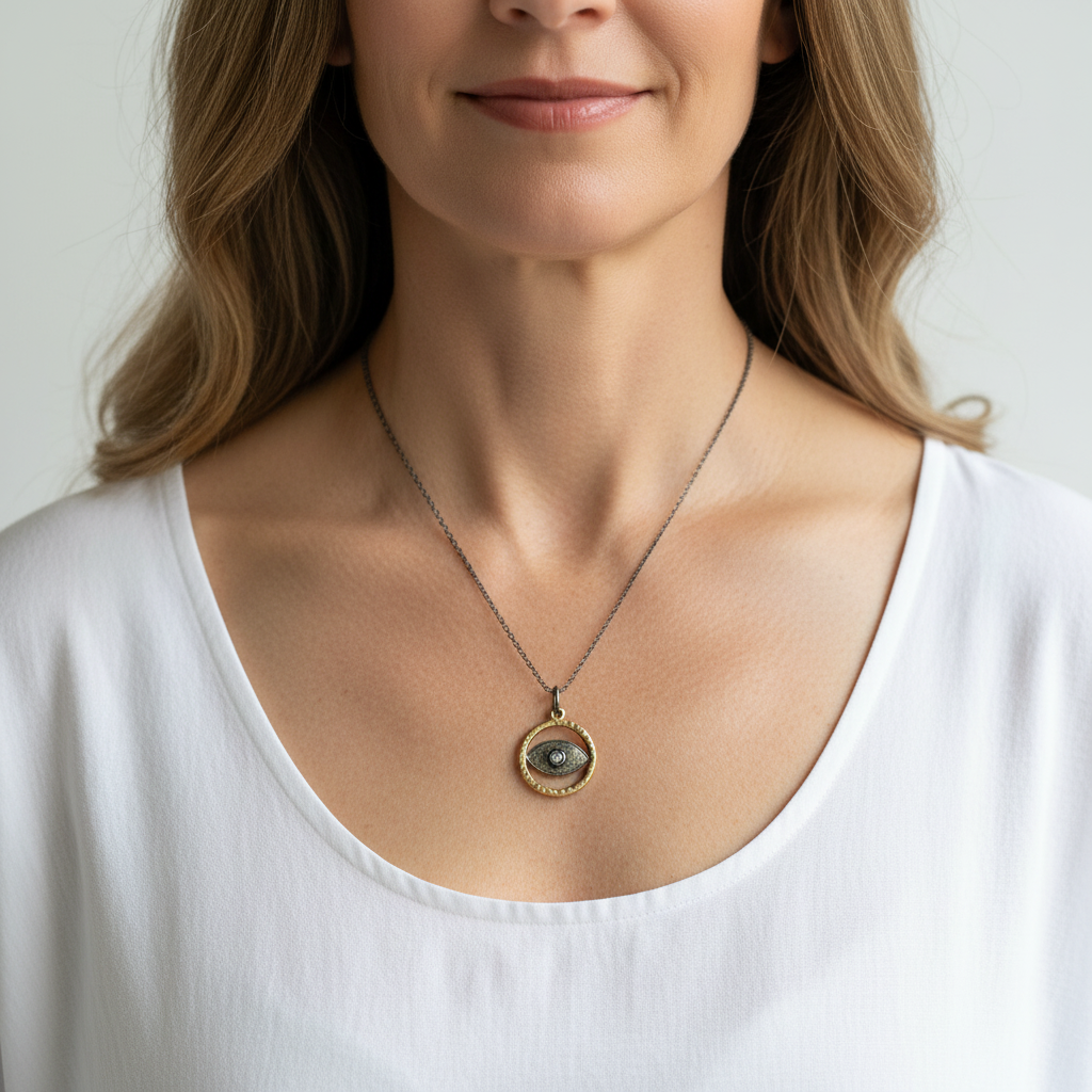 Woman wearing a gunmetal and gold third eye pendant necklace — jewelry for intuition