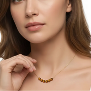 Woman wearing a gold tiger eye pendant necklace, solar plexus chakra jewelry