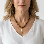 Woman wearing a tiger eye fish pendant necklace