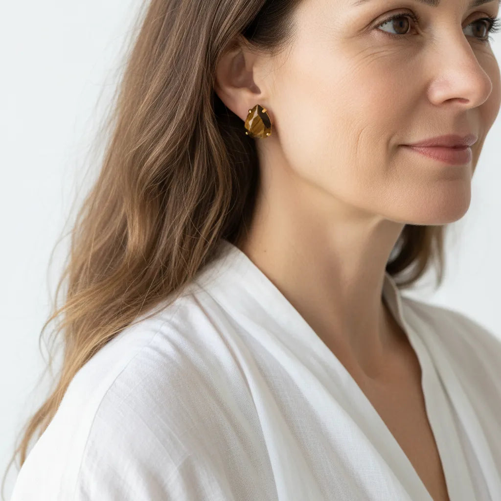 Woman wearing gold tiger eye stud earrings