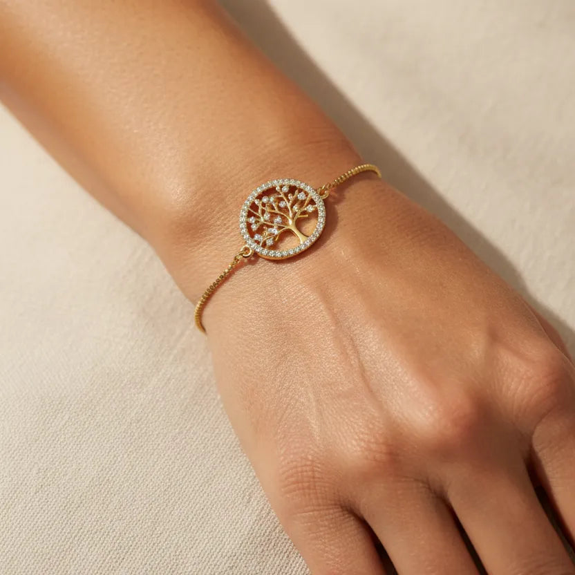 Woman wearing a gold tree of life charm bracelet, spiritual symbol jewelry