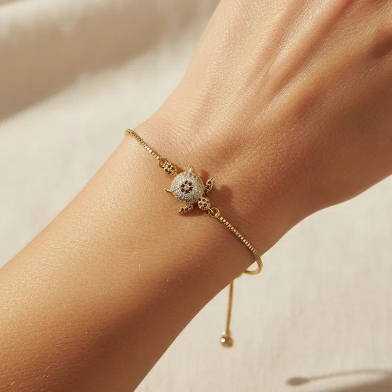 Woman wearing a gold turtle charm adjustable bracelet, spirit animal jewelry