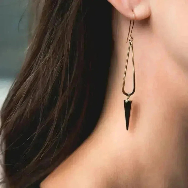 long gold earrings on woman with long dark hair