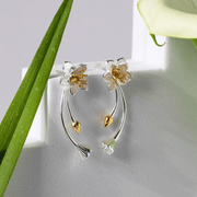 Floral earrings with gold and silver details on a light gray background