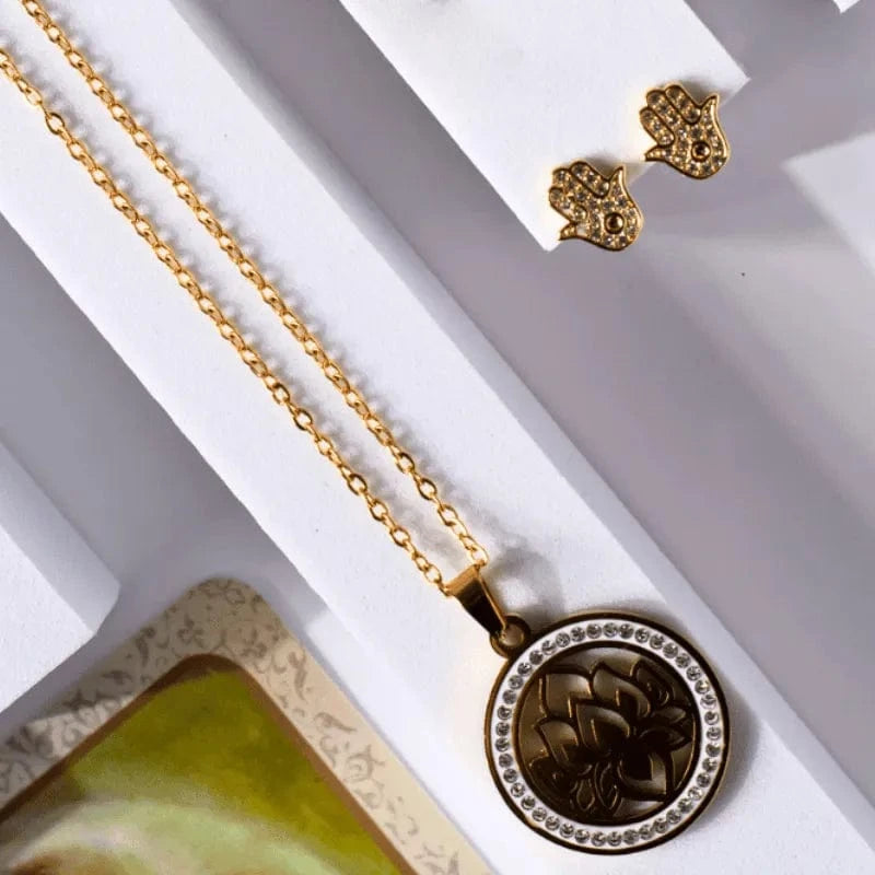 Gold necklace with a pendant on a white surface