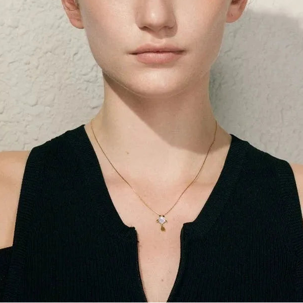 Person wearing a black sleeveless top against a neutral background