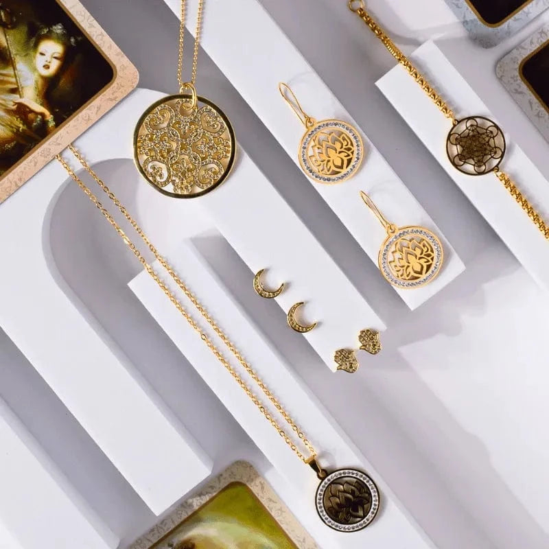 Gold jewelry set including necklaces and earrings on a white surface.