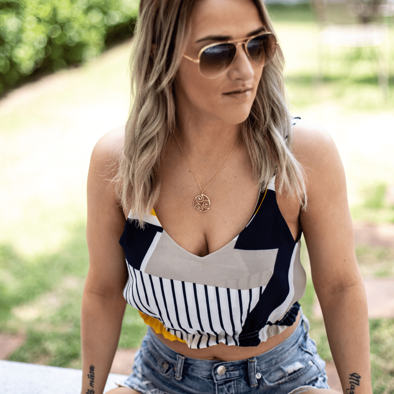 Woman wearing a colorful top and denim shorts outdoors