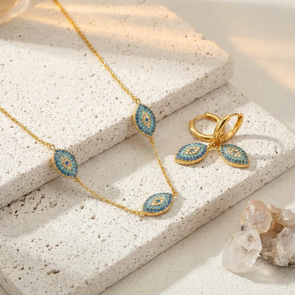 Gold necklace and earrings with blue gemstones on a textured surface