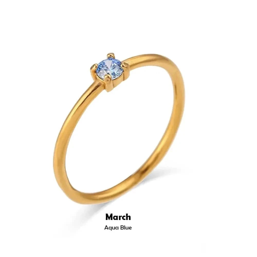 Gold ring with a blue gemstone on a white background