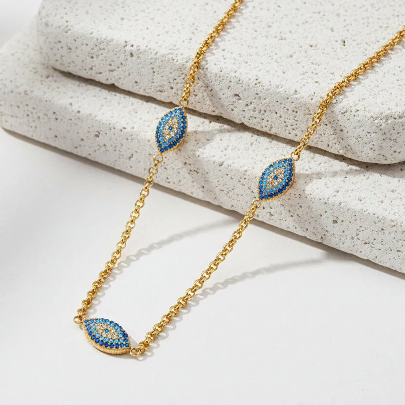 Gold necklace with blue gemstone pendants on a white background
