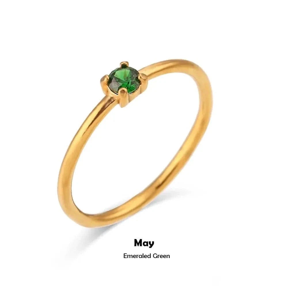 Gold ring with a green gemstone on a white background