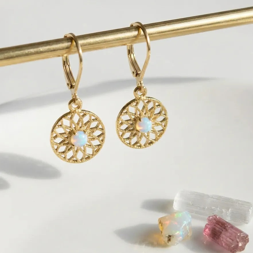 Gold earrings with opal stones on a white background