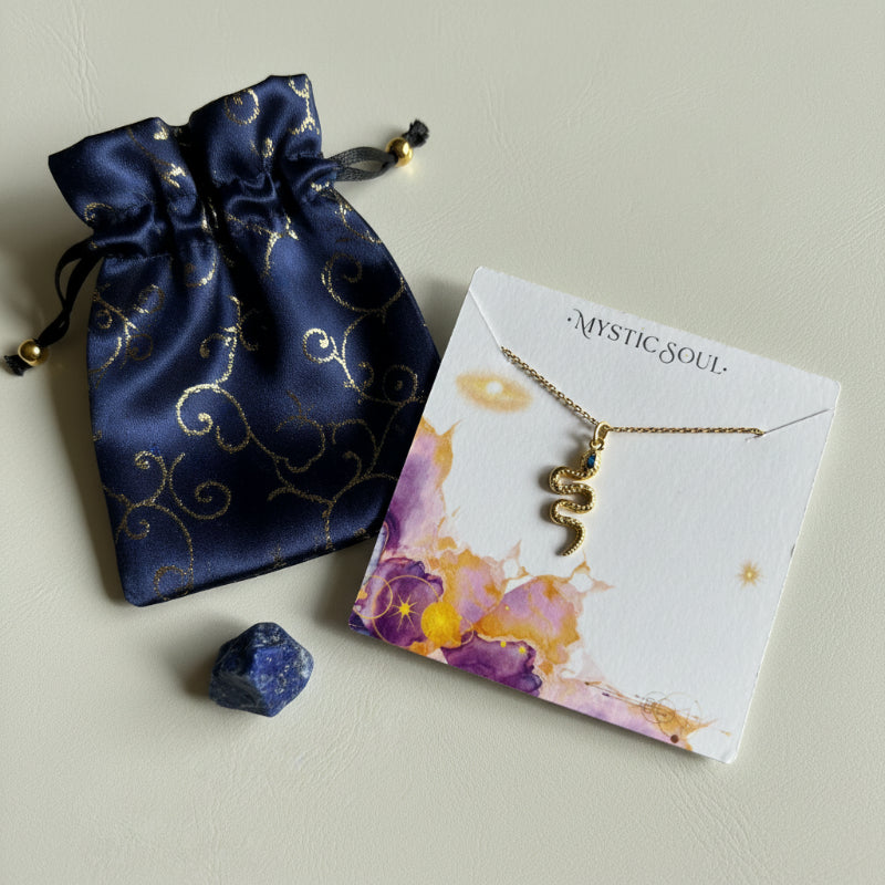 Gold snake necklace with a blue eye on a Mystic Soul Jewelry card and gift bag