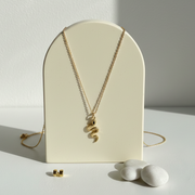 Gold snake pendant necklace with a blue eye — spirit animal jewelry for transformation