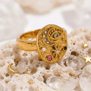 Gold celestial moon ring on a textured surface with starry background