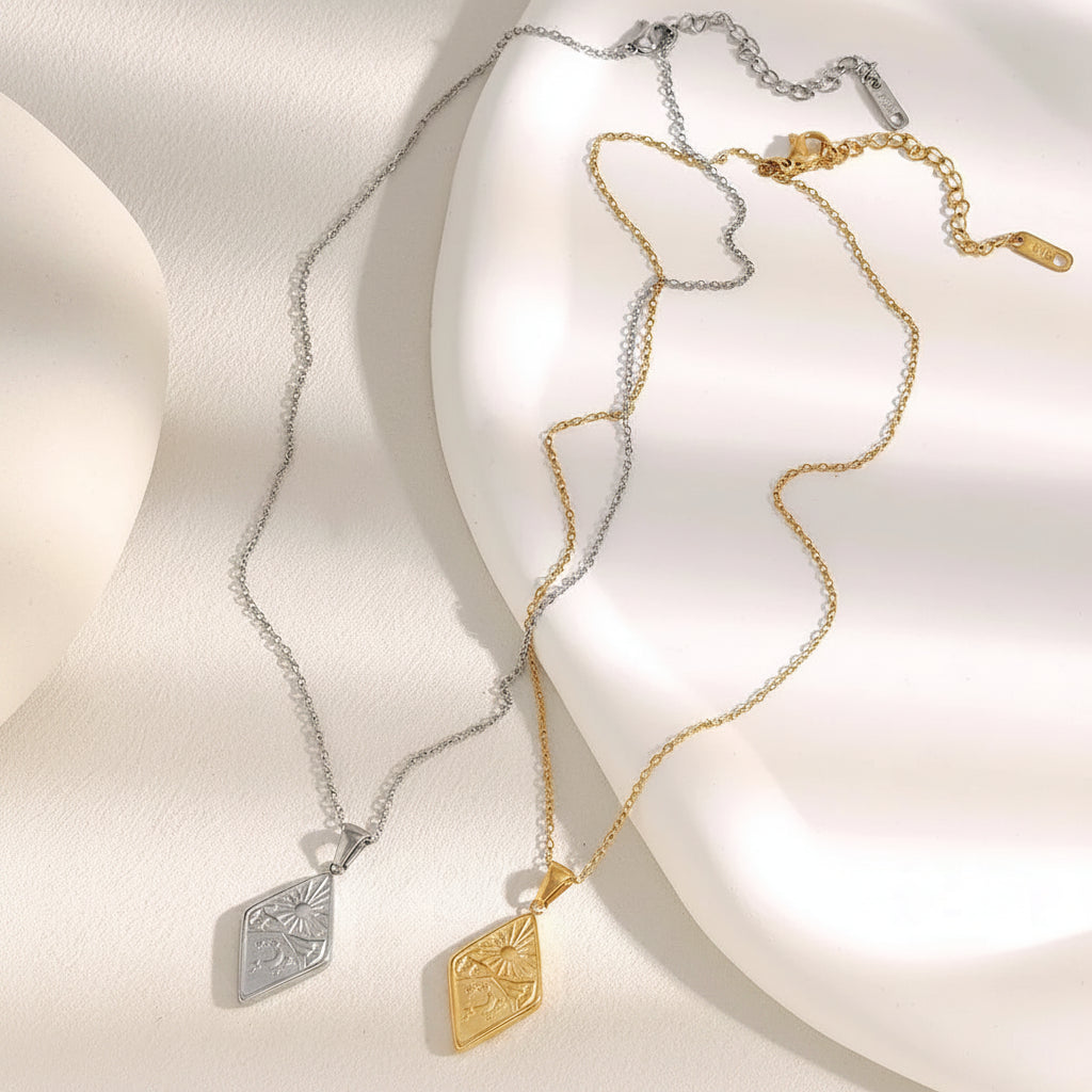 Two necklaces, one gold and one silver, on a soft white background