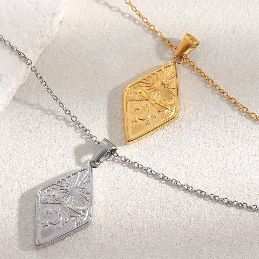 Two geometric pendants, one gold and one silver, on a white background.