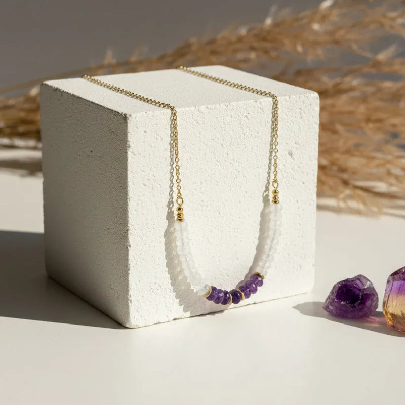 Graduated moonstone and faceted amethyst necklace hanging, largest stones at centre front