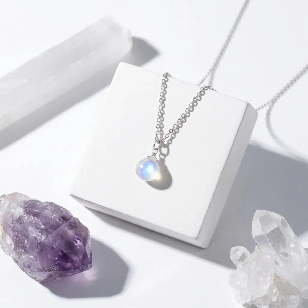 Moonstone Crown Chakra pendant necklace on white surface for gentle intuition and clarity