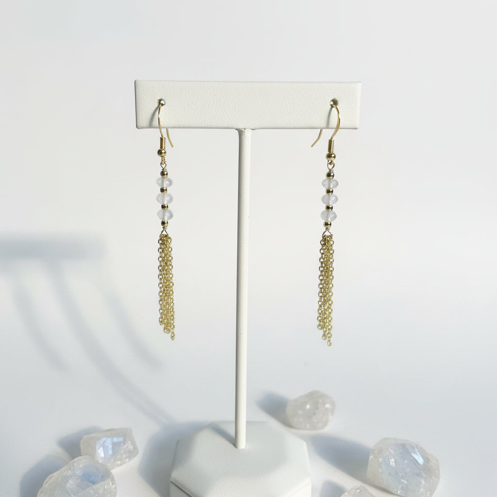Gold moonstone tassel earrings with faceted white stone and cascading chain — June birthstone jewelry
