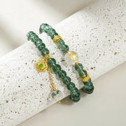 Green beaded bracelet with gold accents on a light green background